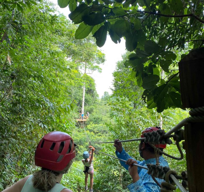 A group of adventurers enjoying an exhilarating ziplining experience at Maya World Zipline in Belize's Stann Creek District.