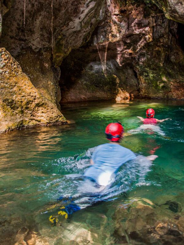 People swimming at the entrance of ATM Cave.