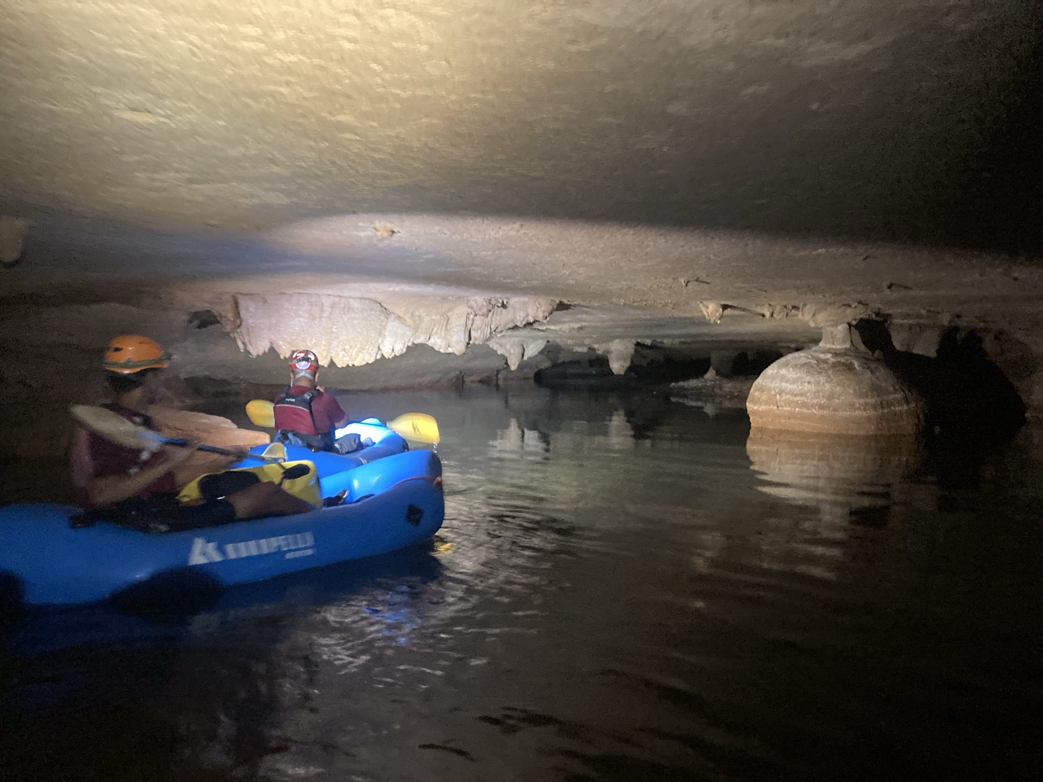 Tube kayaks on the water in a dark cave