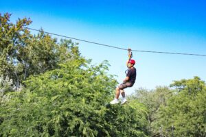 Bocawina Zipline Adventure: Guy enjoying a thrilling ziplining experience in Belize's rainforest.